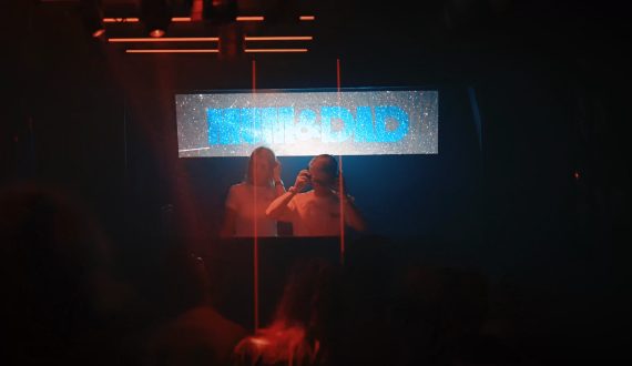Mum from Mum & Dad DJ duo mixing live as the crowd dances in a club